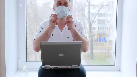 A man sitting on the windowsill working on a computer Stock Footage 128002458
