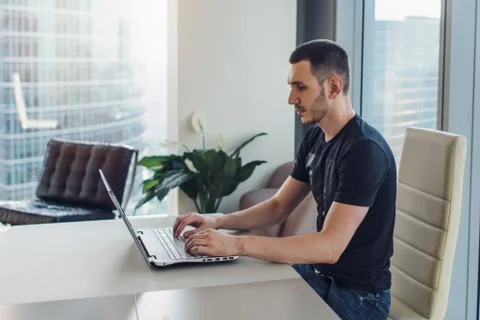 Man sitting at workplace and using laptop Fotos Stock