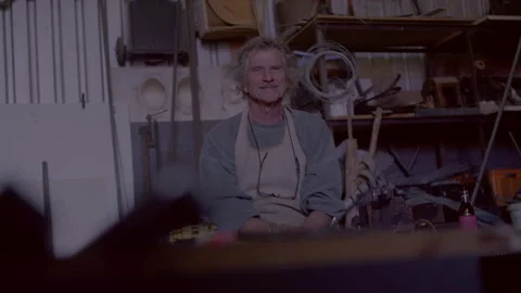 Man sitting in the workshop and laughing while looking straight at the camera Stock Footage 278994924