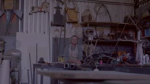 Man sitting in a workshop and looking straight at the camera Stock Footage 278995335
