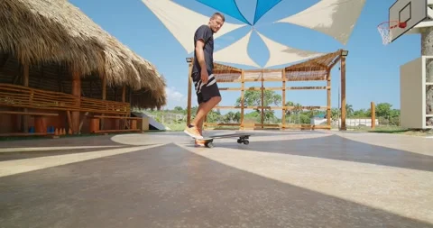Man with skateboard outside, checking smartwatch. Stock Footage 241614237