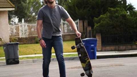 Man skateboarding skating around empty suburb street alone relaxing and joyful Stock Footage 154760188