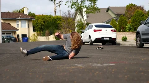 Man skateboarding skating around empty suburb street alone and falling to ground Stock Footage 154760246