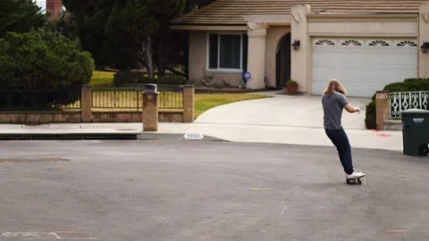 Man skateboarding skating around empty suburb street alone relaxing and joyful Stock Footage 154760531
