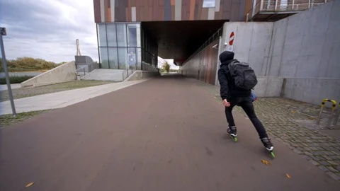 Man skating with backpack on inline skates with three wheels in slow motion Vídeos de archivo 120445509