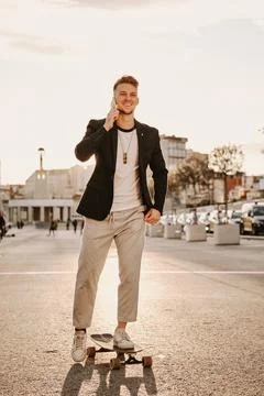 Man skating while talking to the mobile Stock Photos