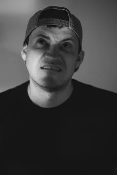 Man with skeptical expression wearing baseball cap. Portrait of confused ma.. Stock Photos