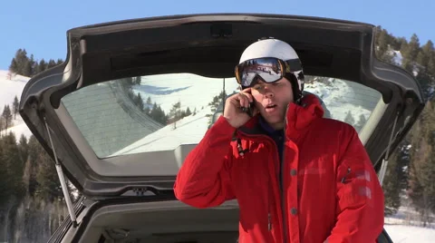 Man in ski gear talking on cell phone near back of car Stock-Footage 935611