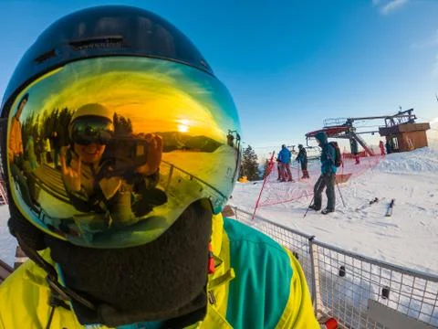 Man in ski mask close up. reflection. snowed mountains on sunset Stock Photos