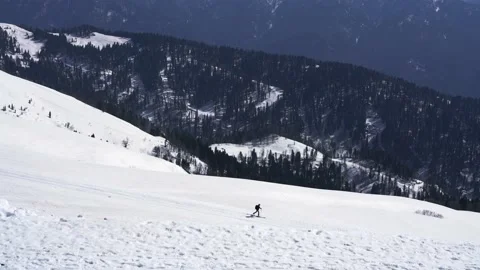 Man skier with backpack skiing in distance in snowy mountains  winter sport Stock Footage 195506325