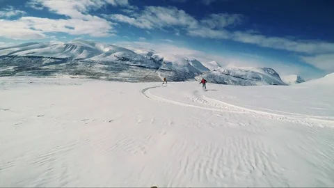 Man skier skiing down mountain and waits with friends in the middle of hill  스톡 동영상 74992470