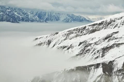 Man skiing down a snowy mountain slope with a breath-taking view of the Alps Stock Photos