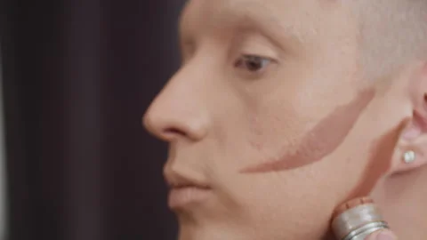 Man skillfully applying stage makeup for dramatic effect 스톡 동영상 283908229