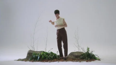 Man skillfully arranges model set in a creative environment with plants Stock Footage 319924975