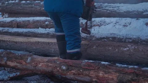 Man skillfully cuts firewood with a chainsaw in a forest setting Stock Footage 324021990