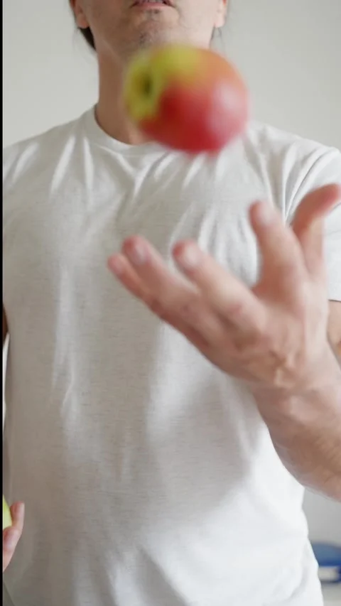 A Man Skillfully Juggling Apples An Engaging Showcase of Talent and Agility in Stock Footage 317779727