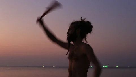 Man skillfully juggling poi on beach near sea water.Island Koh Phangan, Thailand Stock Footage 93465242