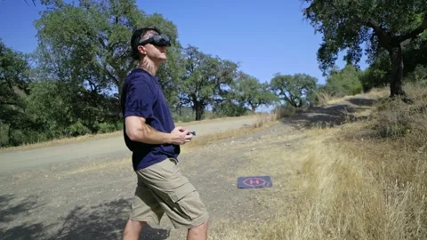 A man skillfully operating a drone in an outdoor setting amidst natures beauty Stock Footage 291847202