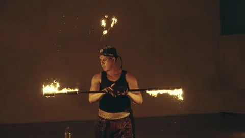 Man skillfully performs an acrobatic fire act, showcasing talent and control, Video stock 305267596
