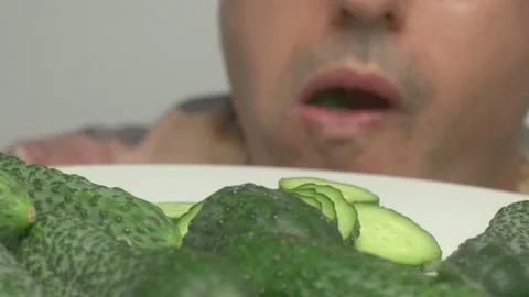 A man is skillfully preparing fresh cucumbers which are perfect for healthy Видео 282378129