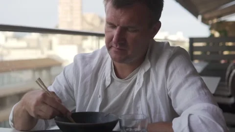 A man skillfully uses chopsticks to enjoy a delicious meal Stock Footage 308872291