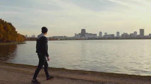 Man skipping stone in lake Stock Footage 99389468