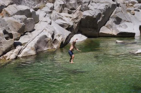 Man slacklining over river Stock Photos