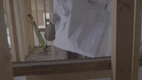 A man slams construction plans onto a desk Stock Footage
