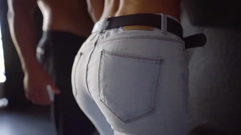 Man is slapping his girlfriend ass, dressed in jeans, close-up of his hand Stock Footage 97102427