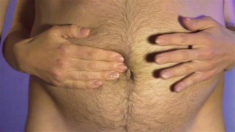 Man slaps his hands against woman's belly and waves of subcutaneous fat spread Stock Footage 128743349