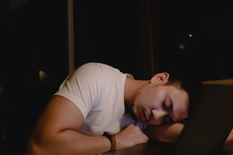 Man sleep on the laptop while working late at night. Concept of tired. Foto stock
