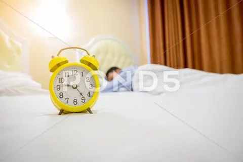 Man sleeping with alarm clock. Stock Photos