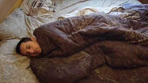 Man sleeping and waking up alone in the bed, close up of face. Headshot of adult Stock Footage 104050336