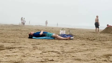 Man Sleeping on Beach Mat as Seagull Moves Near Bags at Woolacombe Beach Devon Vídeo Stock 346221109