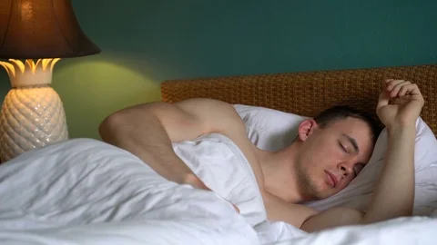 The man is sleeping in the bed Stock Footage 75549802