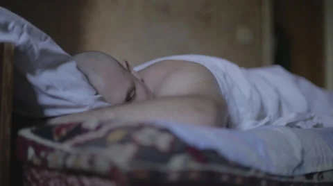 Man sleeping on a bed in an old apartment Video stock 55106462