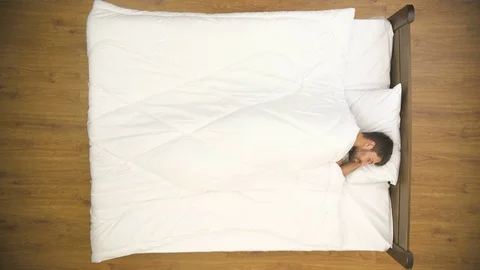 The man sleeping on the bed. Real time capture. View from above Stock Footage 71964718