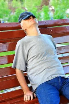 Man sleeping on bench Stock Photos