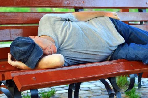 Man sleeping on bench Stock Photos