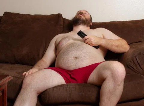 Man sleeping on the couch with remote in hand Stock-Fotos