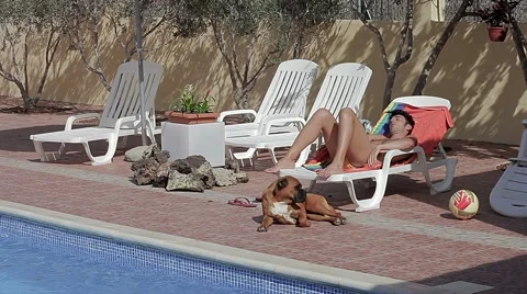 Man sleeping with dog by the pool Stock Footage 40105135