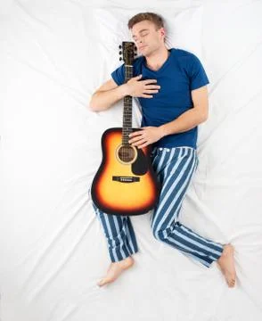 Man sleeping with a guitar Stock Photos