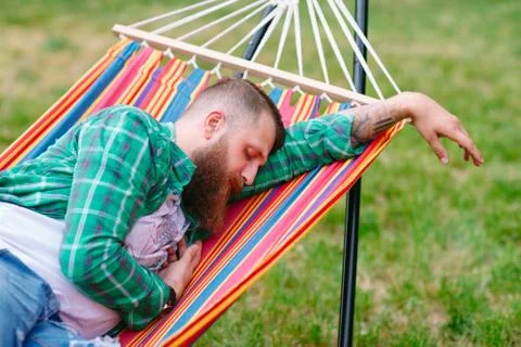 The man is sleeping on a hammock. Stock Photos