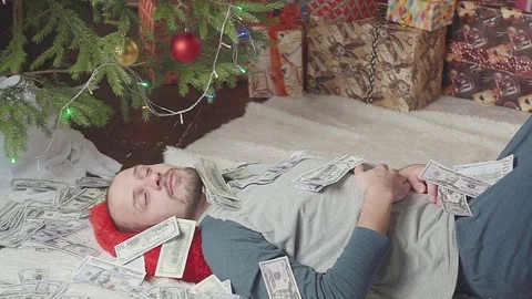 A man is sleeping with a lot of dollars and a Christmas tree Vídeo Stock 81536711