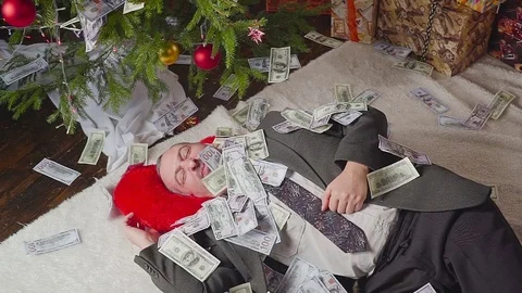 A man is sleeping with a lot of dollars and a Christmas tree Vídeo Stock 81569964