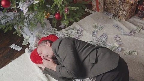 A man is sleeping with a lot of dollars and a Christmas tree Vídeo Stock 81570858