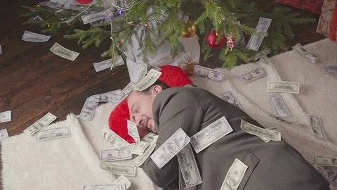 A man is sleeping with a lot of dollars and a Christmas tree Vídeo Stock 81574305