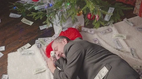 A man is sleeping with a lot of dollars and a Christmas tree Vídeo Stock 81574558