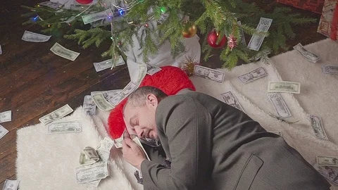 A man is sleeping with a lot of dollars and a Christmas tree Vídeo Stock 81575153