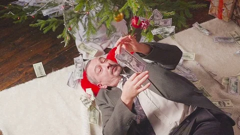 A man is sleeping with a lot of dollars and a Christmas tree Vídeo Stock 81577569